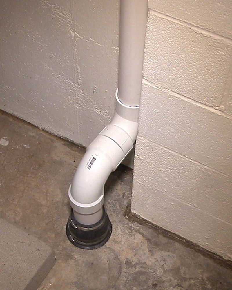 Interior radon suction point piped through a Mesa County basement slab